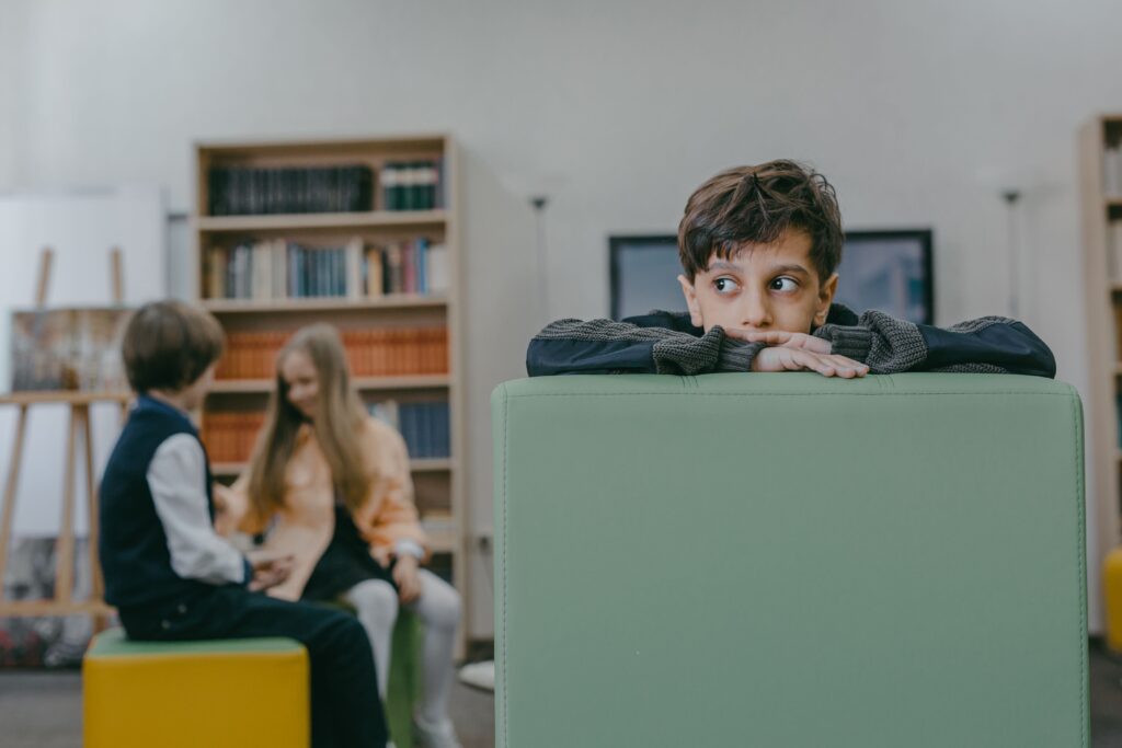 Un enfant assis sur son lit, cartable au sol, refusant de partir à l'école - credits Mikhail Nilov Mikhail Nilov